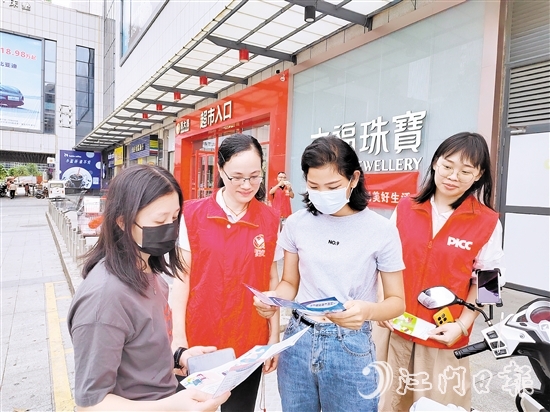 恩平人保財(cái)險(xiǎn)工作人員向群眾派發(fā)宣傳折頁(yè)，普及金融知識(shí)。
