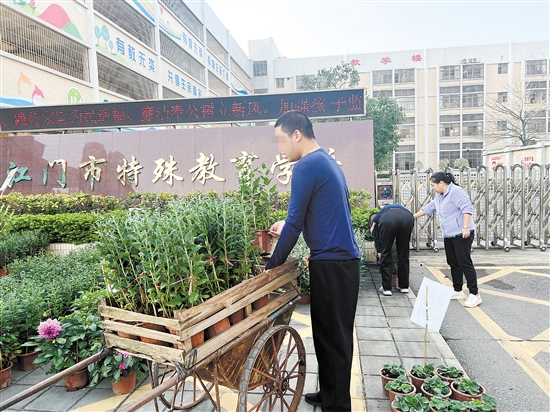 學(xué)生們搬運(yùn)迎春花，為義賣作準(zhǔn)備。