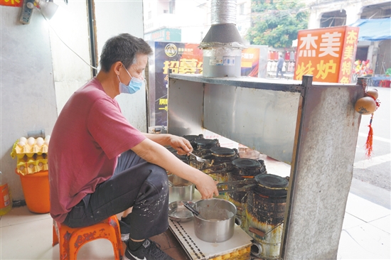 店鋪老板正在烤制爐底糍。