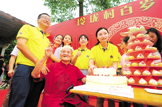 董淑猛（前排左一）、徐娜（豎大拇指者）等人為梁如旺老人慶祝百歲生日。