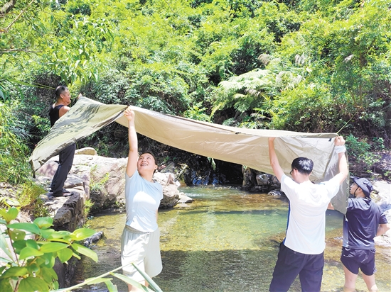 夏季，市民在戶外露營時搭棚防曬。