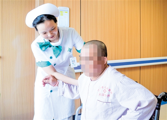 護(hù)士攙扶雙下肢無(wú)力患者上病床。
