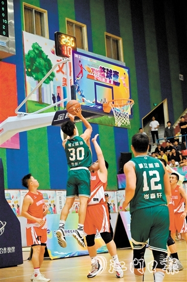 萬村籃球賽江門市級賽決賽現(xiàn)場，橫江村隊(duì)隊(duì)員迎著防守跳投得分。