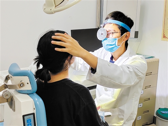 醫(yī)生為患者檢查鼻子。