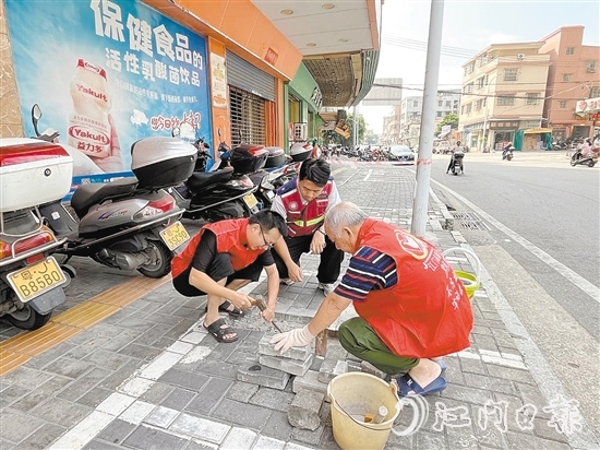 網(wǎng)格員和志愿者一同修復路面。