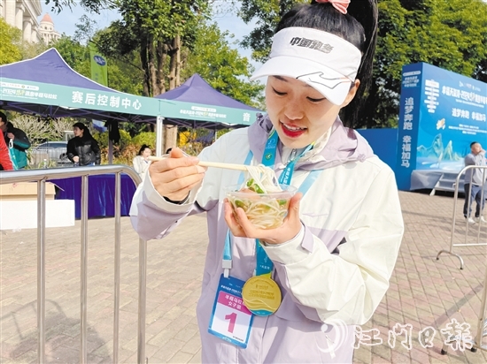 恩平溫泉半程馬拉松女子組冠軍郭利亞品嘗恩平瀨粉并點(diǎn)贊。