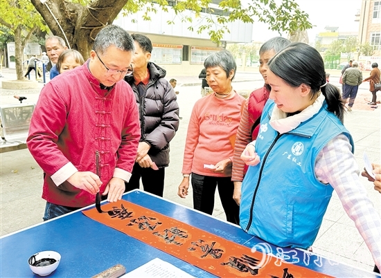 書法家手寫春聯(lián)，為群眾送祝福。