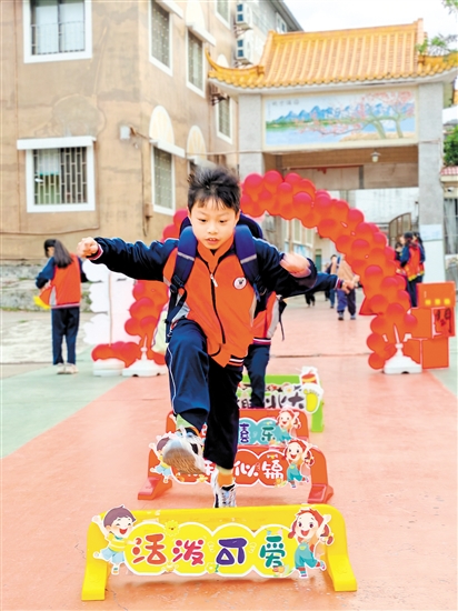 蓬江區(qū)荷塘鎮(zhèn)聯育小學學生跨過吉祥欄。