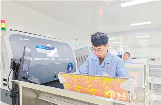 在鶴山中富生產(chǎn)車間，員工操作自動(dòng)化設(shè)備趕制電路板。