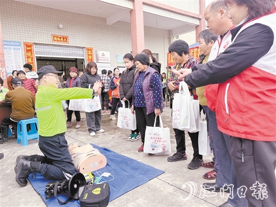 在應(yīng)急安全知識(shí)宣講攤位前，志愿者耐心講解示范急救技能，提升村民的安全意識(shí)和自救互救能力。