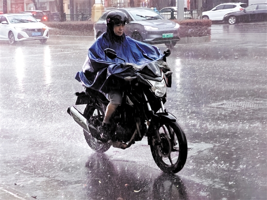 昨天，在市區(qū)東華一路，一位市民騎著摩托車在雨中前行。