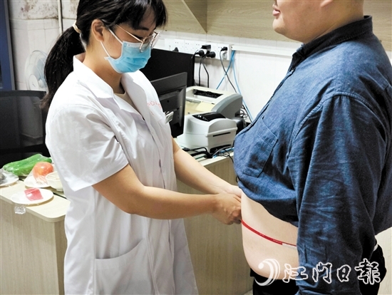 醫(yī)生為記者測(cè)量腰圍。