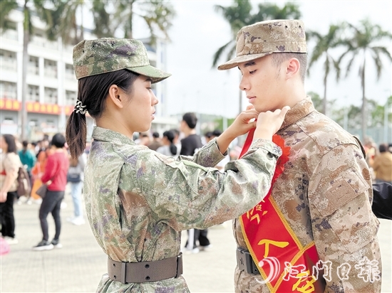 在歡送儀式現(xiàn)場，老兵姐姐為新兵弟弟整理軍裝。