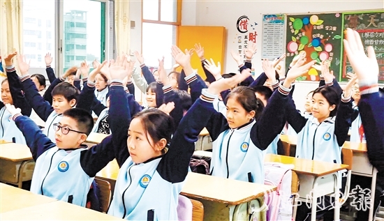 學(xué)生們在課桌前跟隨節(jié)奏做起“室內(nèi)課桌操”。