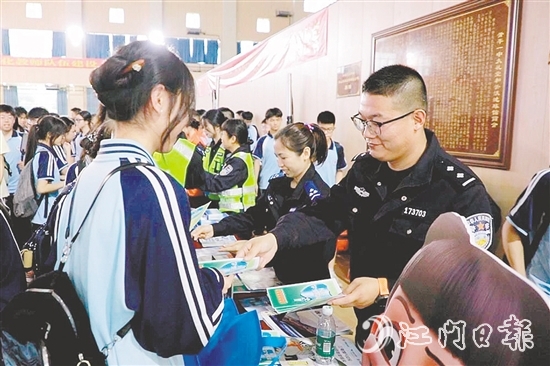 民警向?qū)W生發(fā)放安全知識宣傳資料。