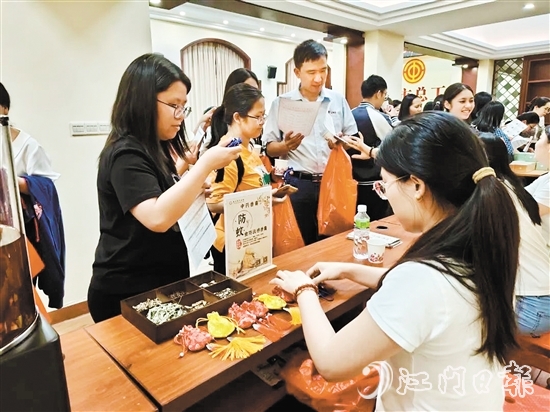 職工們與醫(yī)生探討中藥的成分和比例，制作防感驅(qū)蚊中藥香囊。