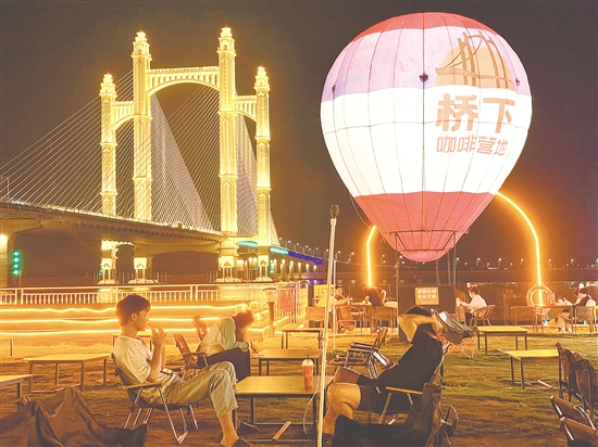 夜幕降臨，潭江兩岸燈火闌珊，市民、游客在“橋下咖啡營地”品咖啡、賞夜景，享受愜意時光。