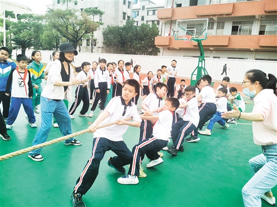 雙方隊(duì)員緊握長繩，齊心協(xié)力，鼓足勁拼命往后拉，全力以赴為班級榮譽(yù)而戰(zhàn)。