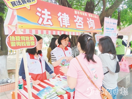 在法律援助攤位，司法系統(tǒng)黨員志愿者耐心解答群眾的法律咨詢。