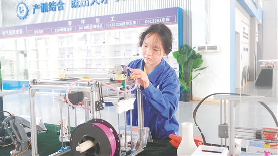 馮曉熒在操作3D打印機(jī)。