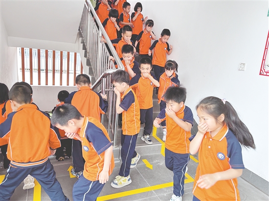 學(xué)生們彎腰低頭、捂住口鼻，按照預(yù)定路線有序撤離。
