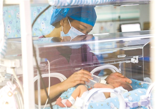 這是一雙小心翼翼的手。在江門市婦幼保健院新生兒科，護(hù)士李麗婷化身臨時“奶媽”，手持奶瓶給早產(chǎn)兒喂奶。她時而調(diào)整奶瓶角度，時而放緩速度，用耐心與愛心為小生命構(gòu)筑溫暖港灣，陪伴他們跨越成長路上最初的難關(guān)。