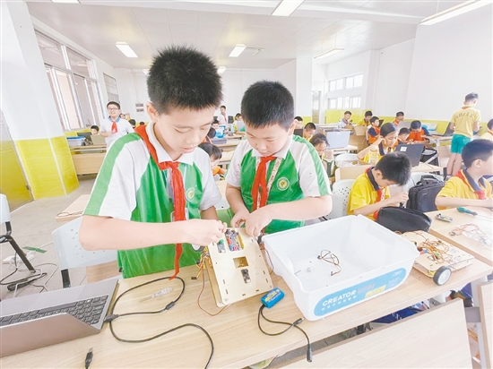 賽場上，小選手們?nèi)褙炞⒌剡M行機器人編程與調(diào)試。