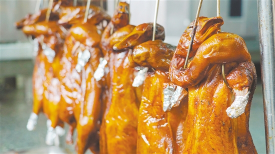 新鮮出爐的燒鵝表皮鮮紅油潤(rùn)，讓人食指大動(dòng)。