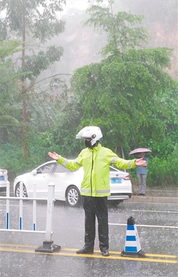 高考期間，交警在大雨中維持交通秩序。