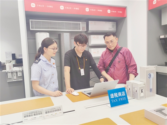 稅務(wù)部門輔導(dǎo)小米之家工作人員為旅客開具退稅申請(qǐng)單。