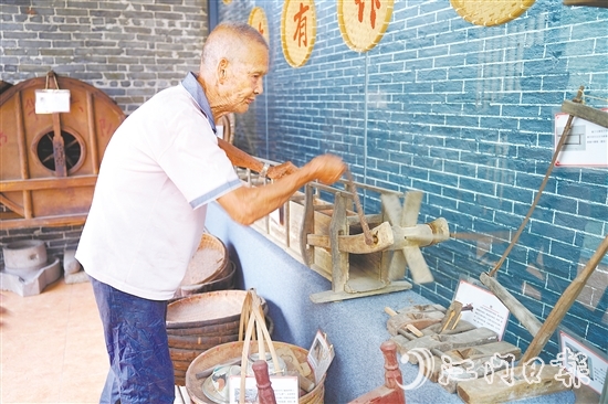 新華村打造農(nóng)耕文化展館，留住鄉(xiāng)村記憶。圖為村中老人向記者介紹農(nóng)具。