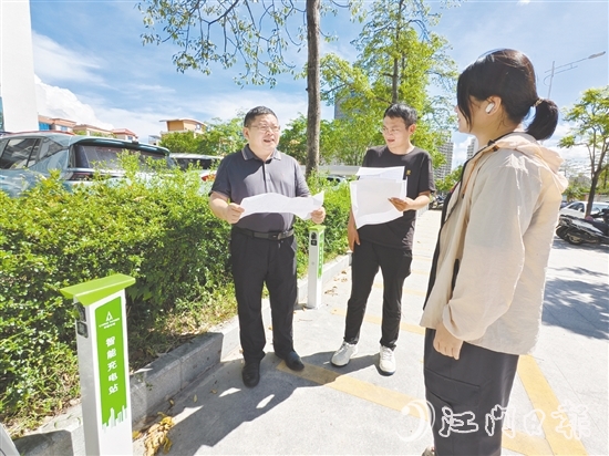 余中宏（左一）與同事一起查看“民生服務充電站”項目建設進度。