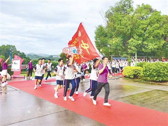 在臺(tái)山市武溪中學(xué)，老師揮舞著“中考加油”的紅旗為考生加油助威。