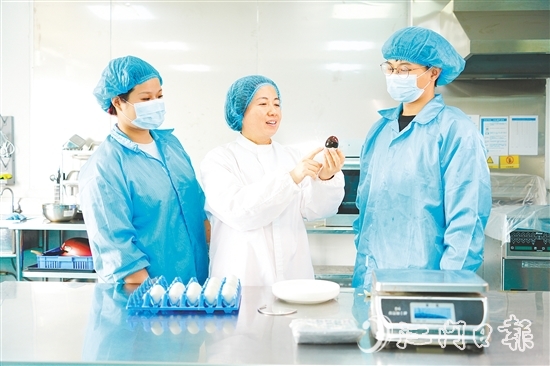 在培訓(xùn)室里，梁艷芬（中間白衣）和大家交流蛋品檢測方式。