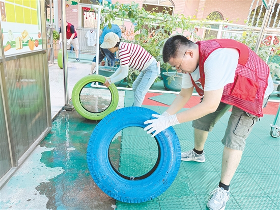 蓬江區(qū)委組織部干部深入幼兒園清理輪胎內(nèi)積水，做好基孔肯雅熱疫情防控工作。