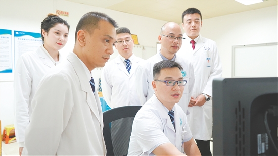 謝志駿（左四）和同事討論影像報(bào)告。