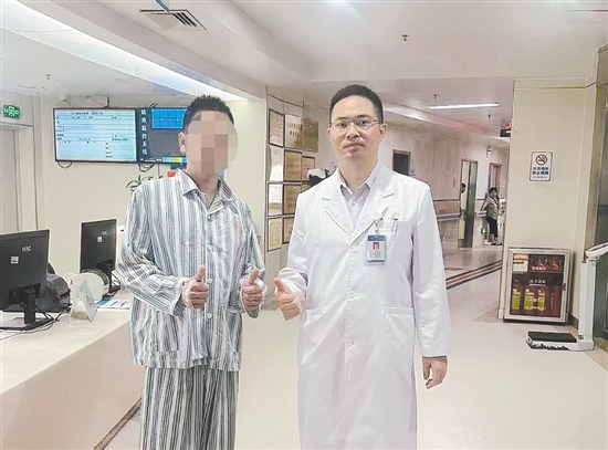 患者和醫(yī)生合影，豎起大拇指表示肯定。