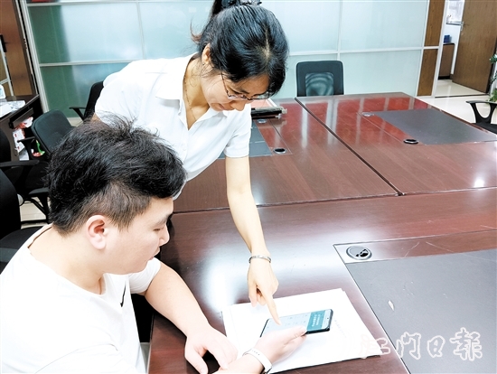工作人員在指導市民線上交存住宅專項維修資金。陸沿任