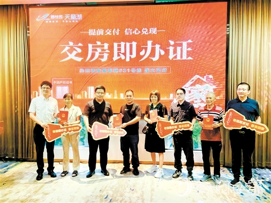 業(yè)主喜拿房產(chǎn)證和鑰匙。